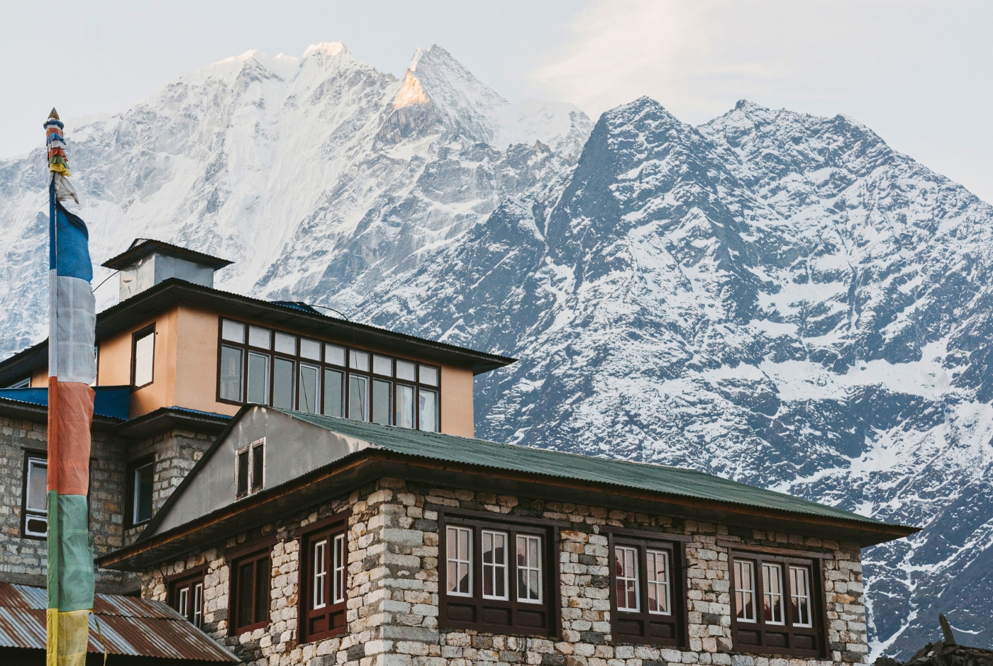 Tone building Everest Region; prayer flag, and snowy mountains