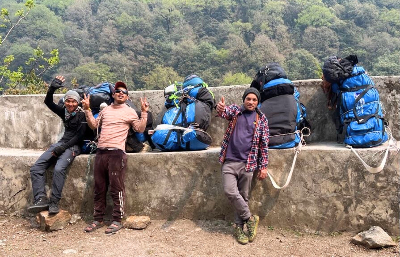 Nepal trekking porters resting with duffel bags during a mountain trek