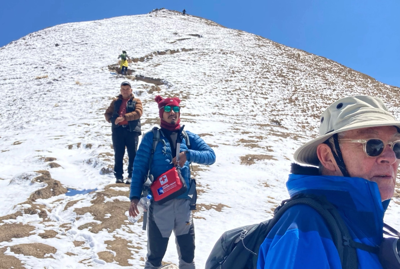 Experienced trekking guide leading a group on a snowy high-altitude trail in Langtang Valley
