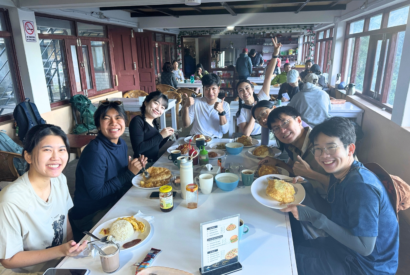 Trekkers enjoying a meal together at a teahouse lodge dining room during Annapurna Base Camp Trek