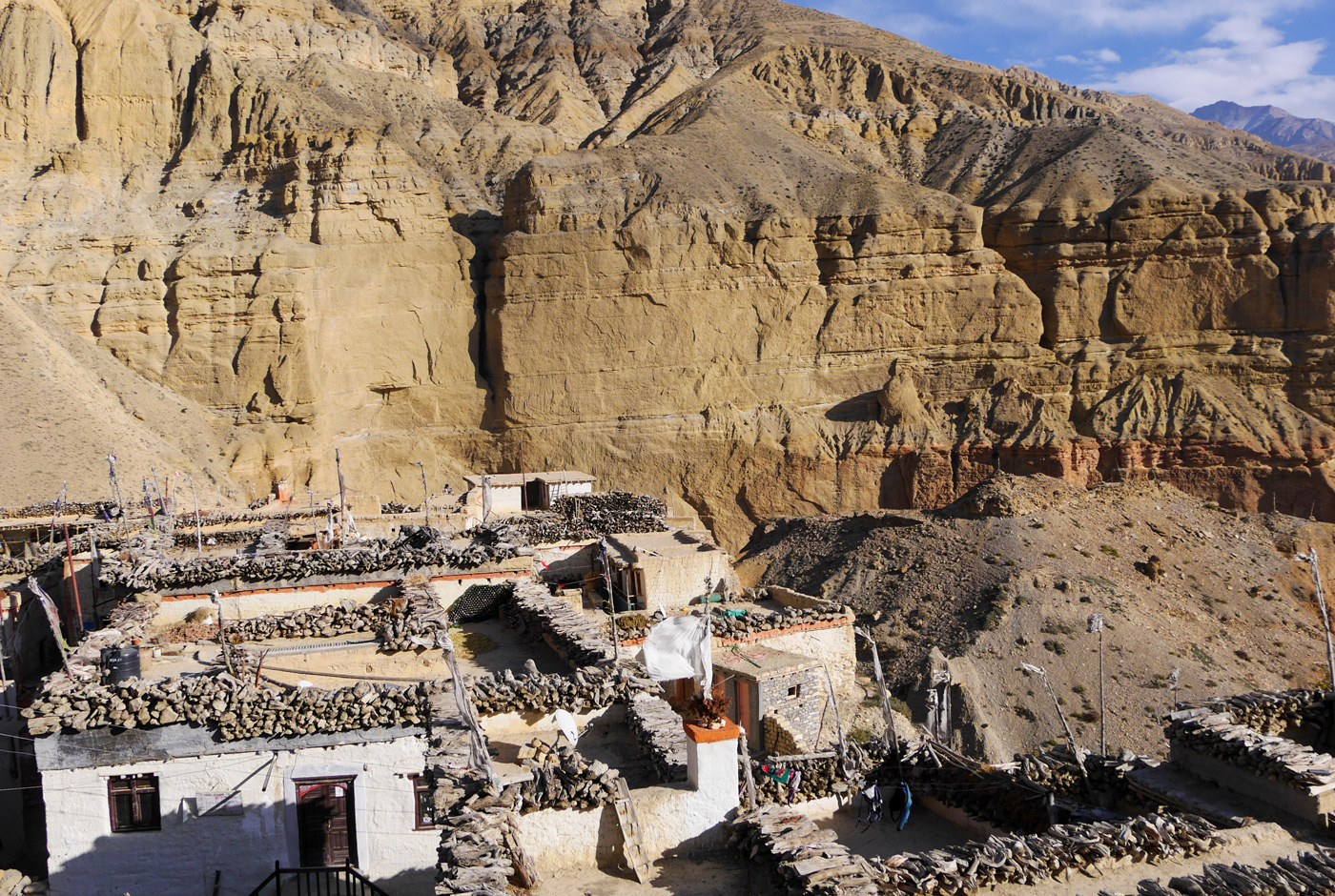 Traditional stone houses of Lo Manthang village in Upper Mustang Nepal set against towering cliff walls