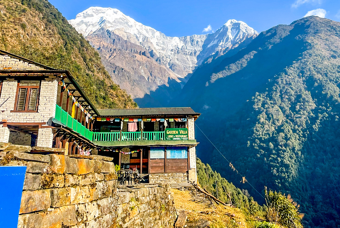 Traditional Stone Teahouse Lodges In Chhomrong Village  With Annapurna South And Hiunchuli Snow Peaks Visible In Background