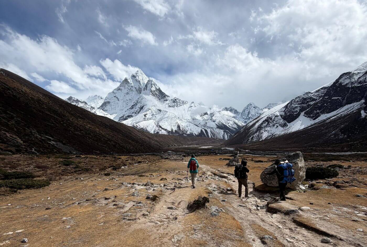 Trekker and porters with organized daypack and duffel bag on Everest Base Camp trail