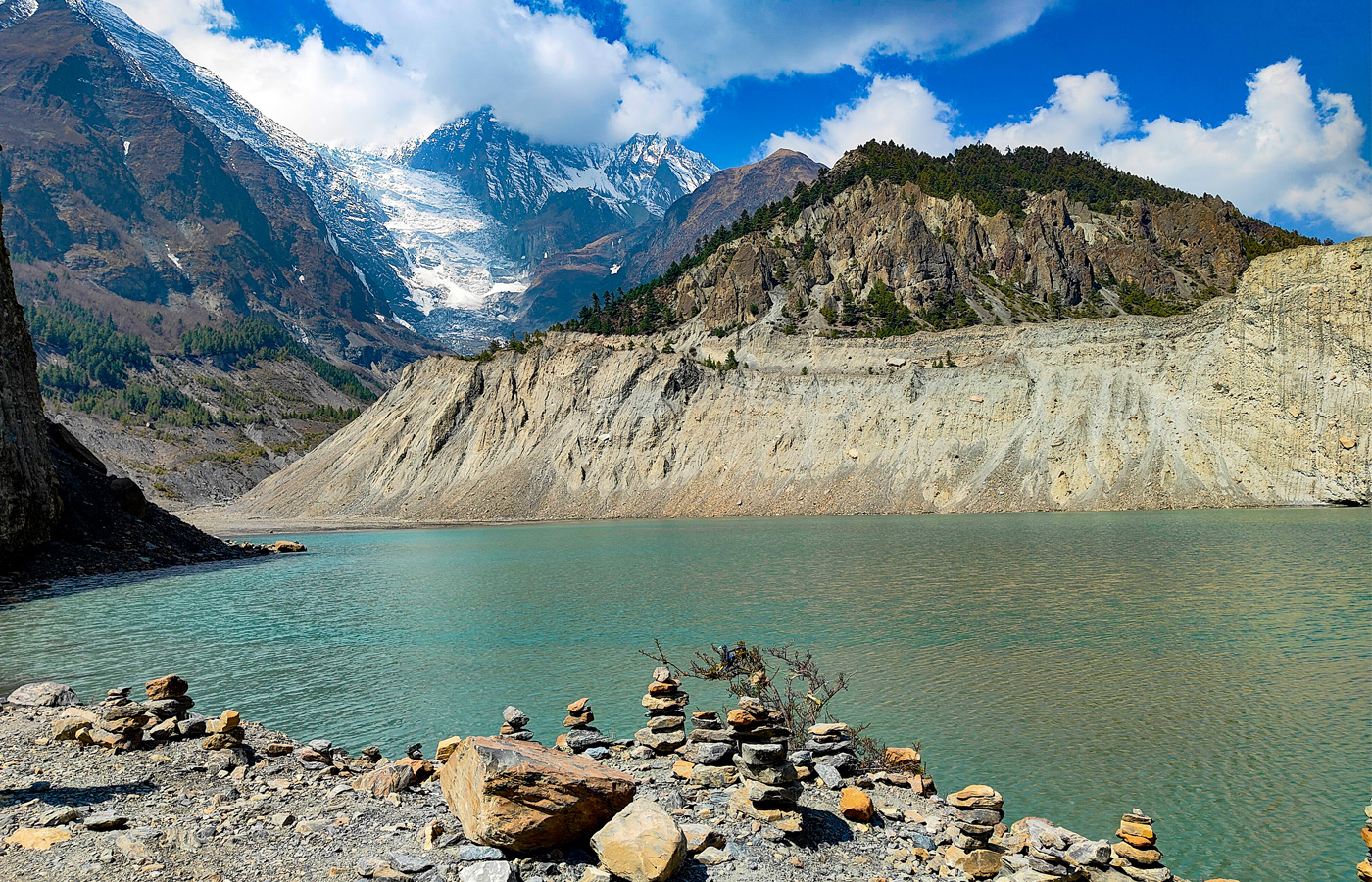Gangapurna Lake near Manang reflecting surrounding Himalayan peaks during acclimatization hike
