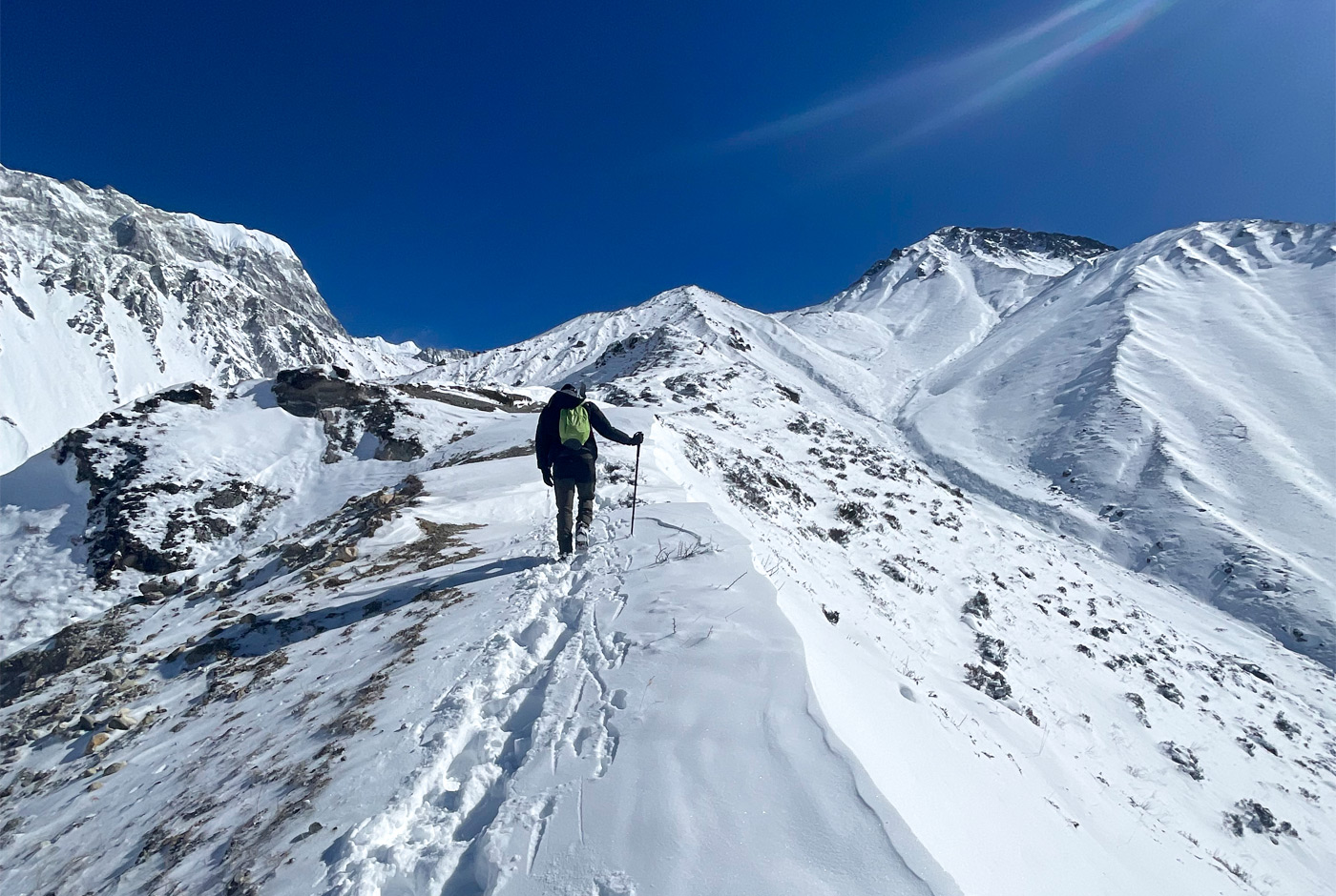 Winter Trekking In Langtang Valley With Snow Covered Trail And Trekker Using Poles In Deep Snow
