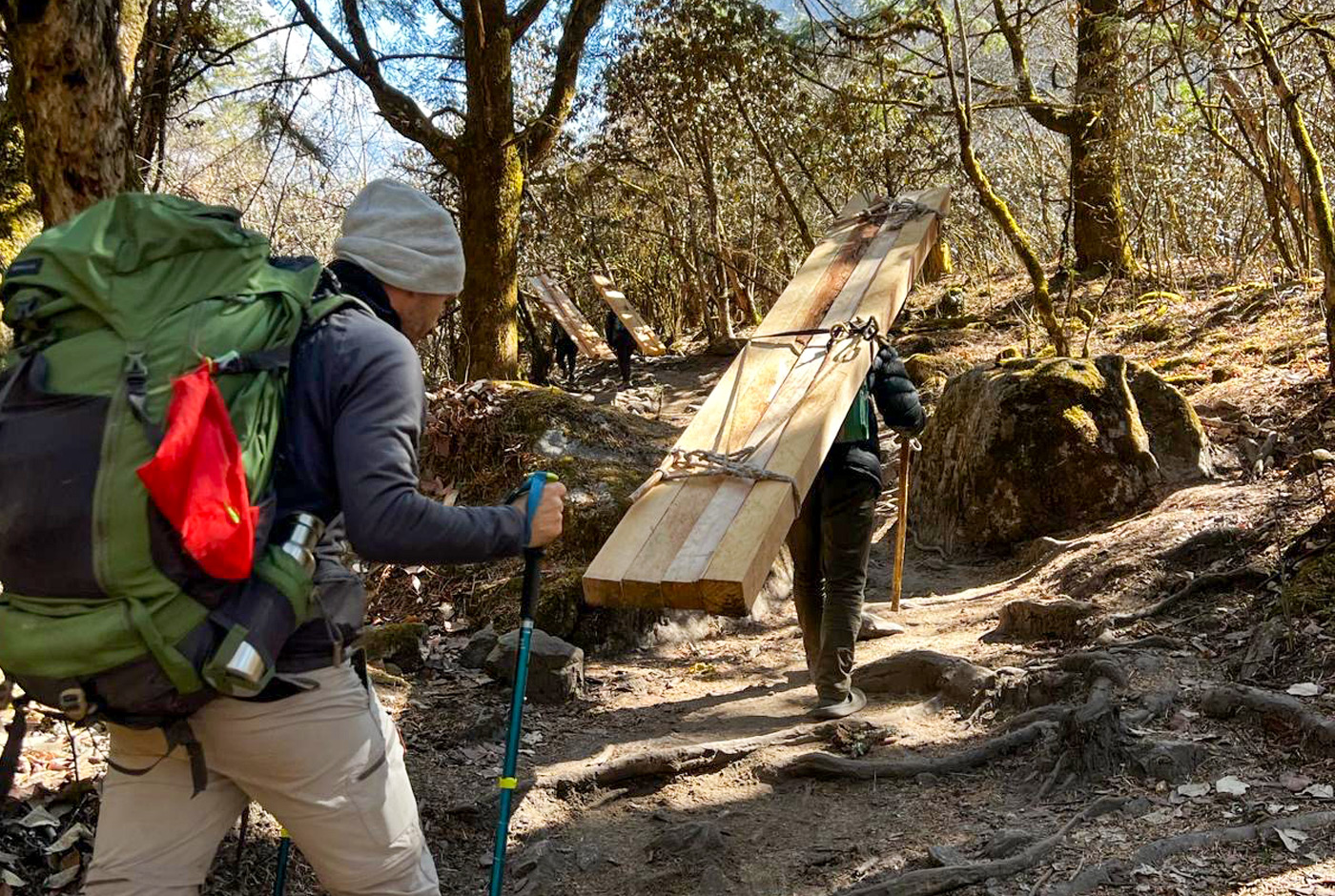 Trekkers And Porter On Forest Path During Langtang Valley Trek