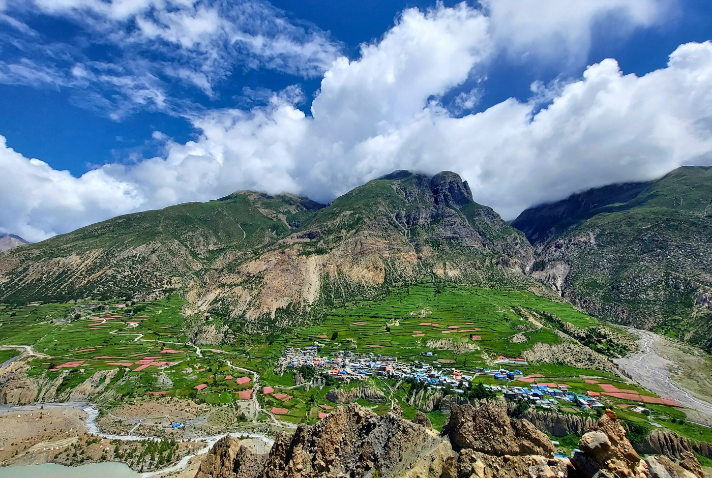 Aerial view of Manang Village in the Annapurna Circuit showing settlement, terraced fields, and surrounding Himalayan mountains